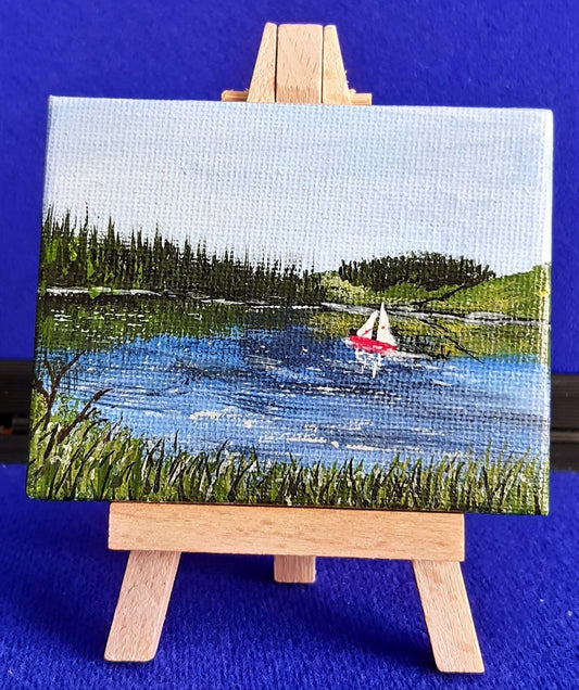 Kielder Sail 2 – Original Mini Gouache Painting with Wooden Easel.
Bring a piece of the dramatic Northumberland wilderness into your home. Kielder Sail is an original, hand-painted gouache artwork capturing a tranquil sailboat gliding across the vast waters of Kielder Reservoir. Complete with its own mini display easel, this charming miniature painting adds a subtle, artistic accent to any desk, shelf, or mantlepiece.
100% Original Art: Signed by the artist—not a print. Unique, one-of-a-kind piece.