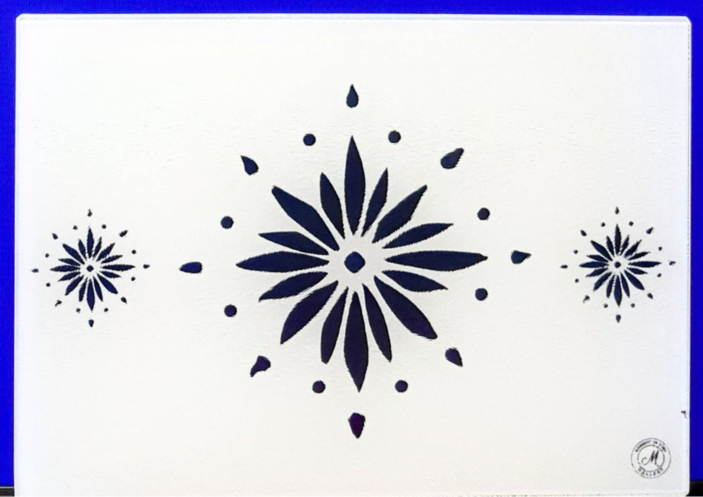 White cutting board with blue flowerburst design. Board displayed on a blue background. Premium glass worktop saver and serving board. A4 size.