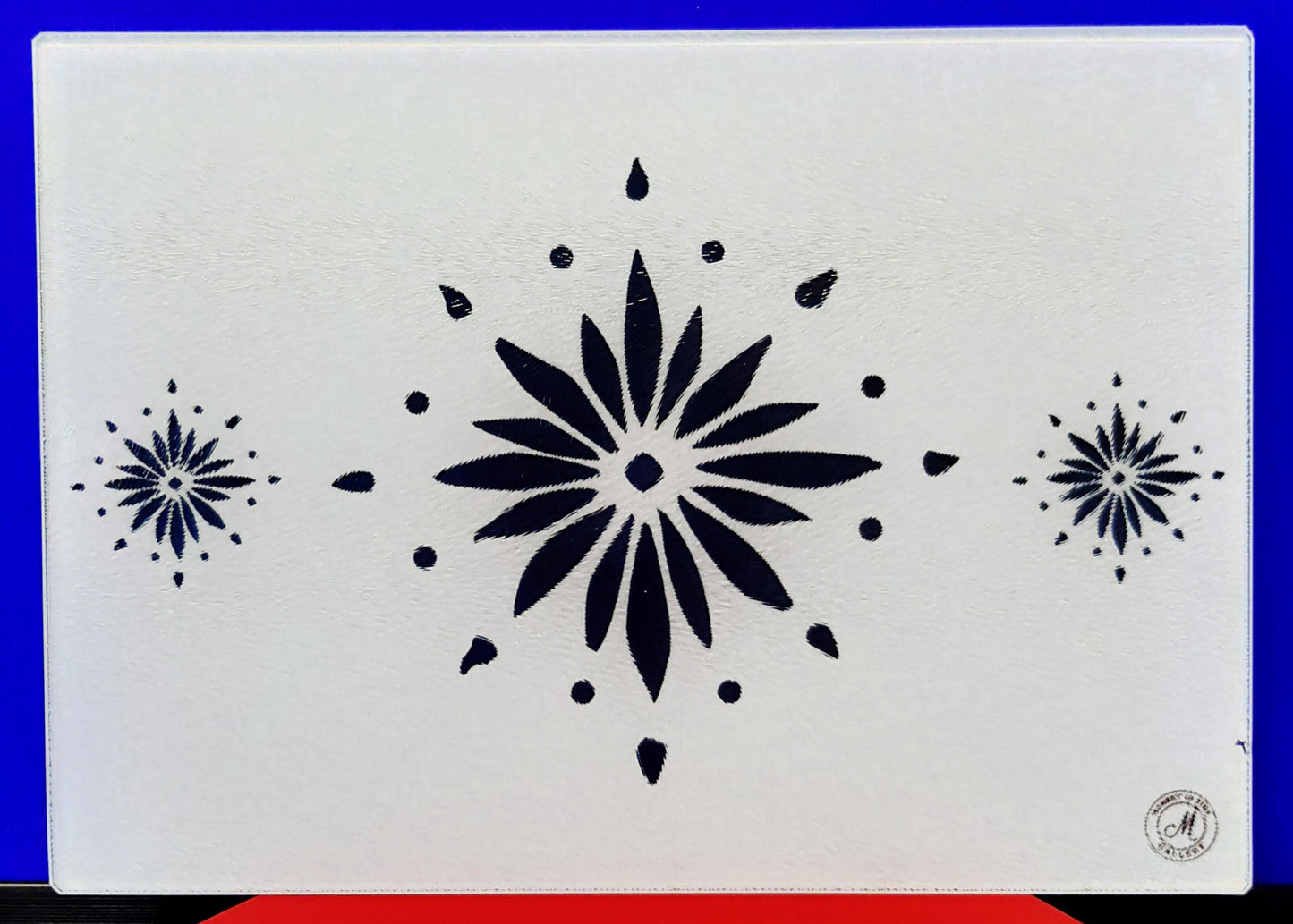 Table mat with decorative blue flowerburst design on a white background. Heat resistant place mats.