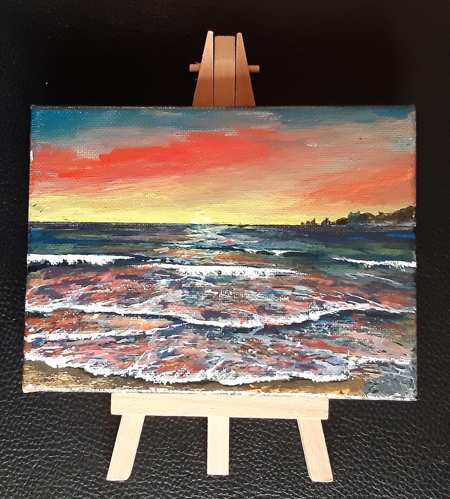 "Dawn Seascape" – Original Mini Gouache Painting with Display Easel.
Bring a warm, tranquil glow into your space with this original, hand-painted seascape.
Inspired by quiet morning horizons, Dawn Seascape captures the gentle warmth of an early sky set against the rhythmic motion of crashing waves. Painted in rich gouache on a medium stretched canvas, this delicate piece is sealed with a protective varnish to preserve its vibrant colors. Canvas size: 6" W x 4.5" H
Easel size: 3.5" W x 7.5" H