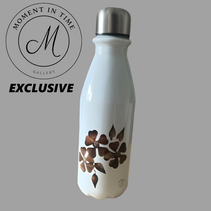 White aluminium water bottle with brown floral design on a gray background, featuring 'Moment in Time Gallery' logo.  650 ml Designer bottle.