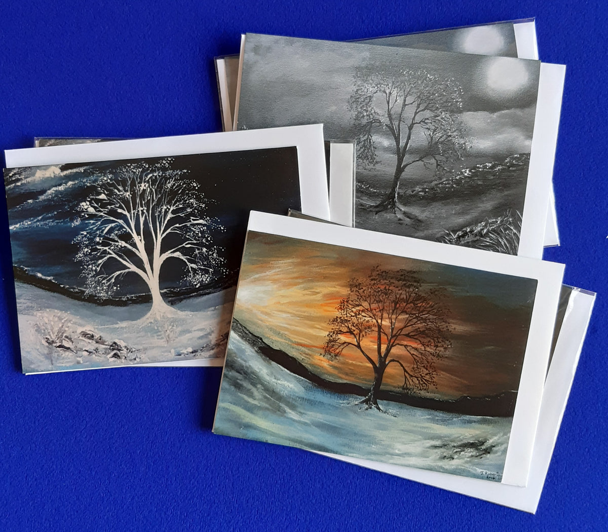 "Mix & Match Sycamore Gap" - Christmas Card Collection.
Bring the quiet majesty of the Great British countryside to your festive greetings with this exclusive collection. Inspired by Northumberland’s most iconic landmark along Hadrian’s Wall—lovingly known as the "Robin Hood Tree"—these original artworks by artist Joanne Roberts make the ideal seasonal choice for nature lovers, hikers, and walkers. Pack consists of 2 Moonlit Sycamore Gap, 2 White Moonlit Sycamore and 2 Sunset Sycamore. Lanscape, size 7"x5" 