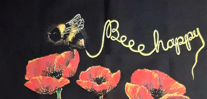 Image of the Bee inscribing gold 'Beee Happy' above a cluster of  poppies. 100% Cotton tea towels.