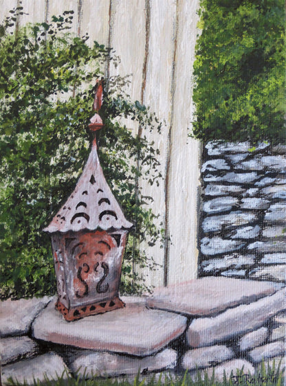 Garden Lantern No. 2 – Original Gouache Painting.
Bring a warm touch of countryside charm into your home with Garden Lantern No. 1. Inspired by a visit to the historic Falstone Barns near Kielder Dam in Northumberland, this original piece captures the serene atmosphere of rural England with exquisite detail in the rustic stonework and soft glowing lantern.
Painted in gouache on canvas and sealed with a protective varnish finish, this vibrant artwork is a unique, one-of-a-kind piece signed by the artist.